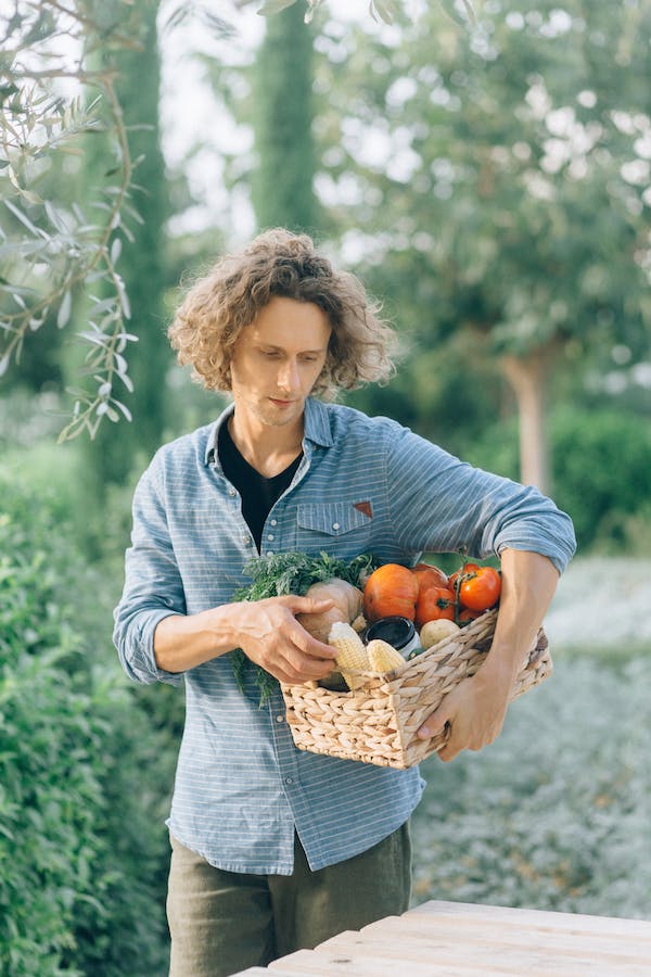 Hombre con cesta de frutas y verduras